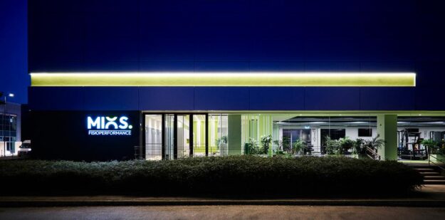 Sede Mios fisioperformance Scorcio notturno della sede Mios Fisioperformance con logo insegna, lunga vetrata