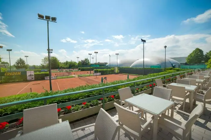 Distesa estiva della club house e sullo sfondo campi da tennis in terra battuta